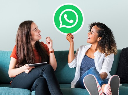 Dos mujeres osteniendo el logo de WhatsApp